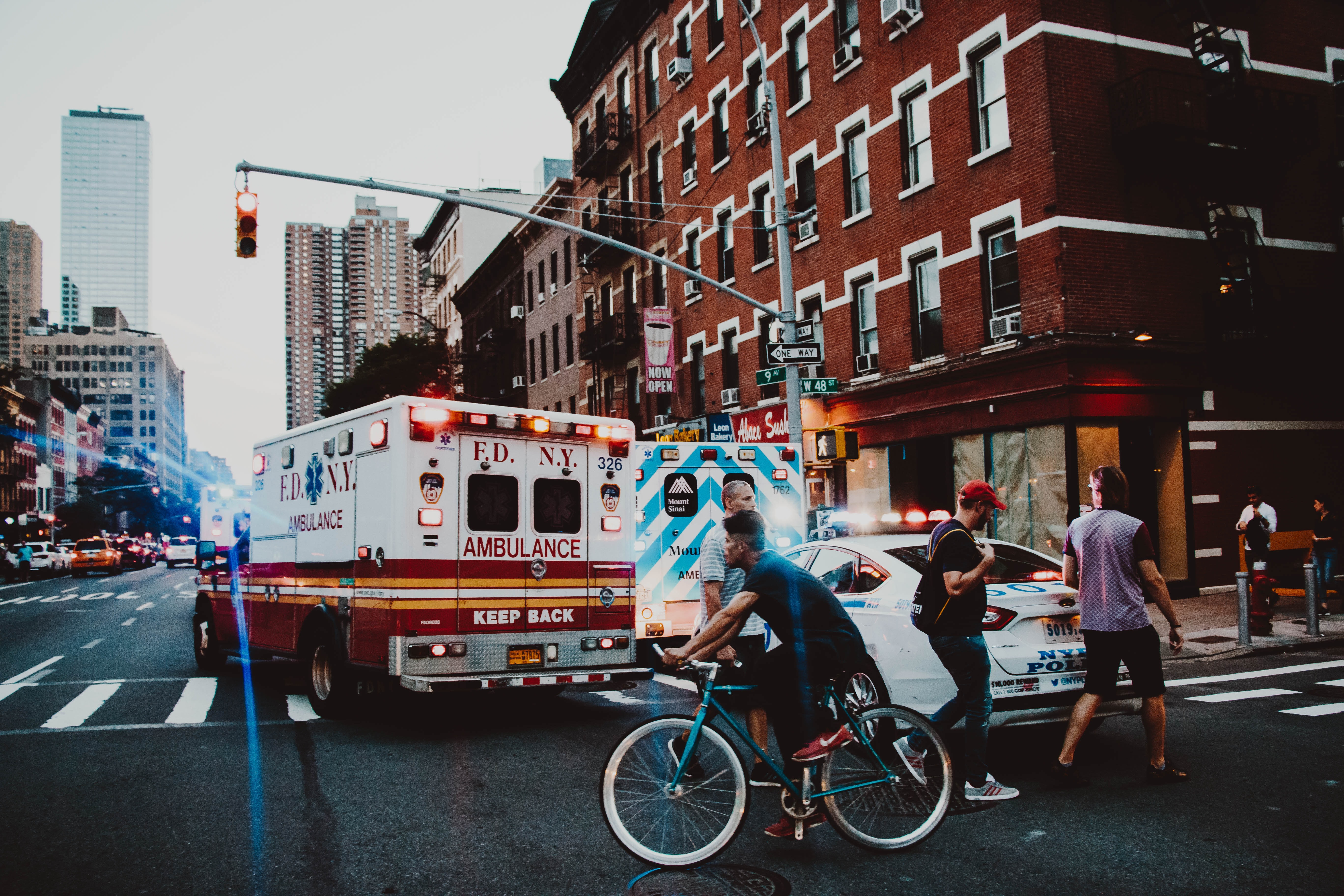 bikerider in front of Ambulance and Police Car